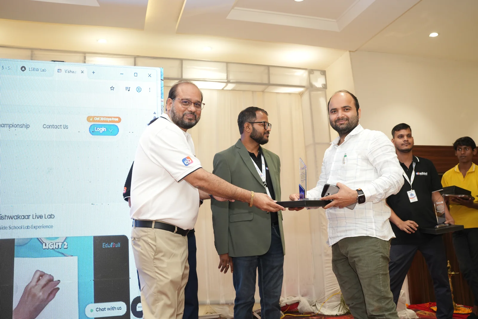 School leader receiving recognition trophy from Edubull leadership team