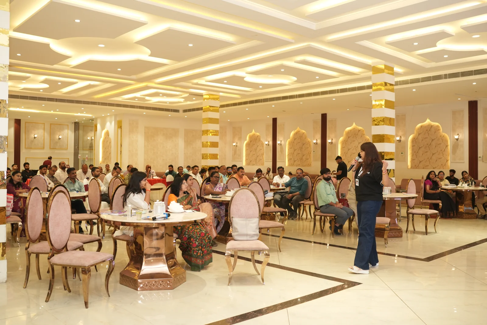 School owners and principals seated at round tables participating in conclave sessions