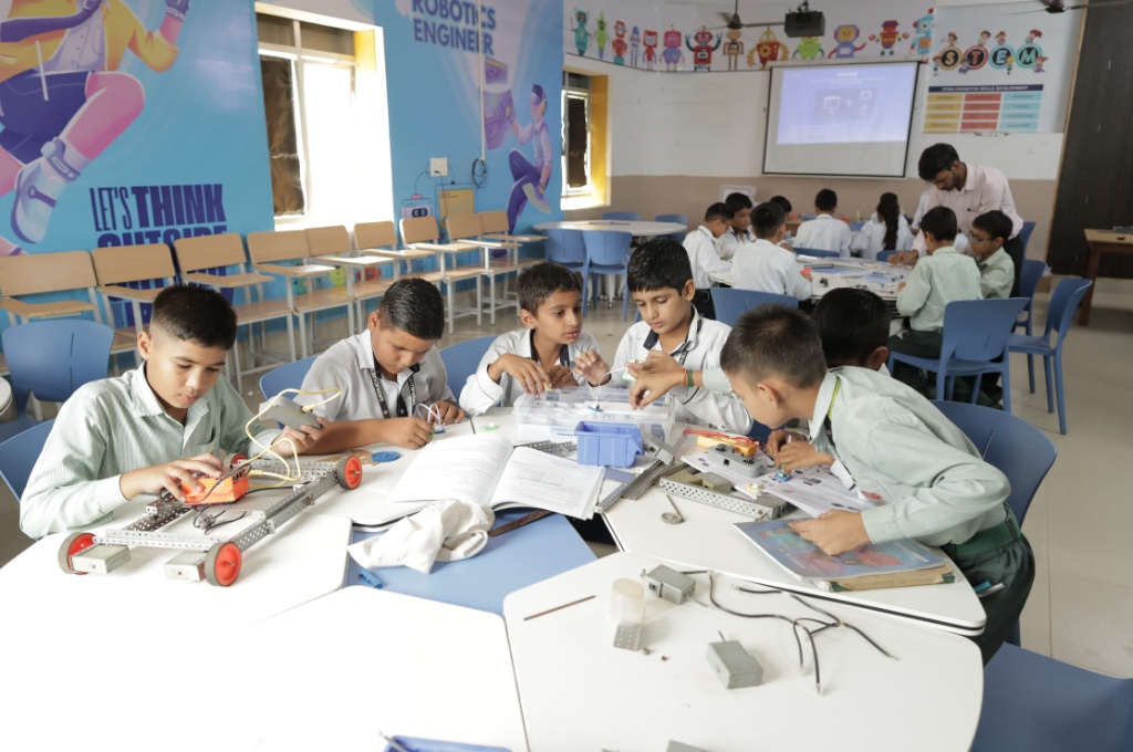 Students assembling STEM robotics and circuit projects in classroom